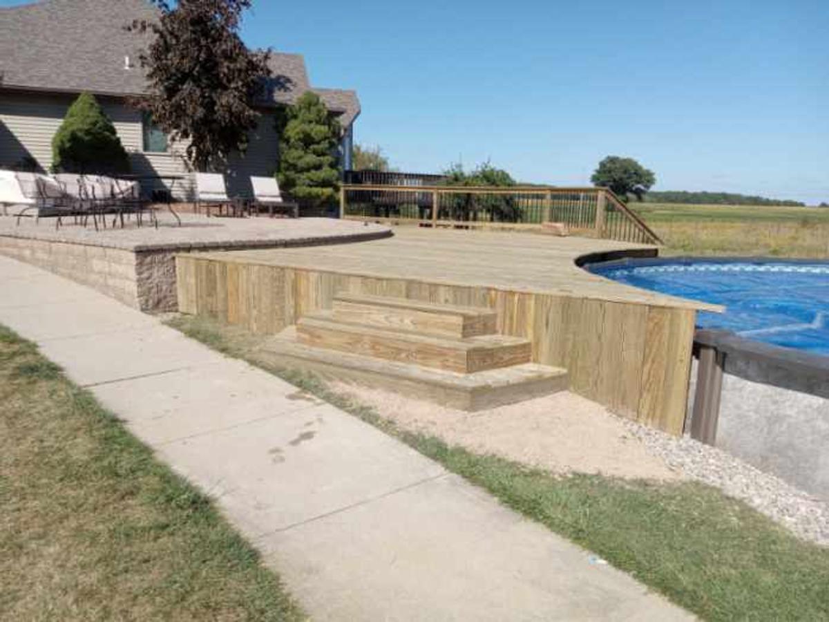 Pressure-treated pool deck with patio and stone wall