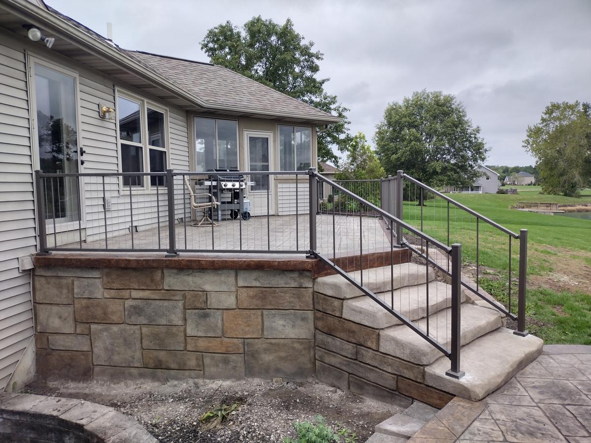 Stone patio deck with metal railings and stairs