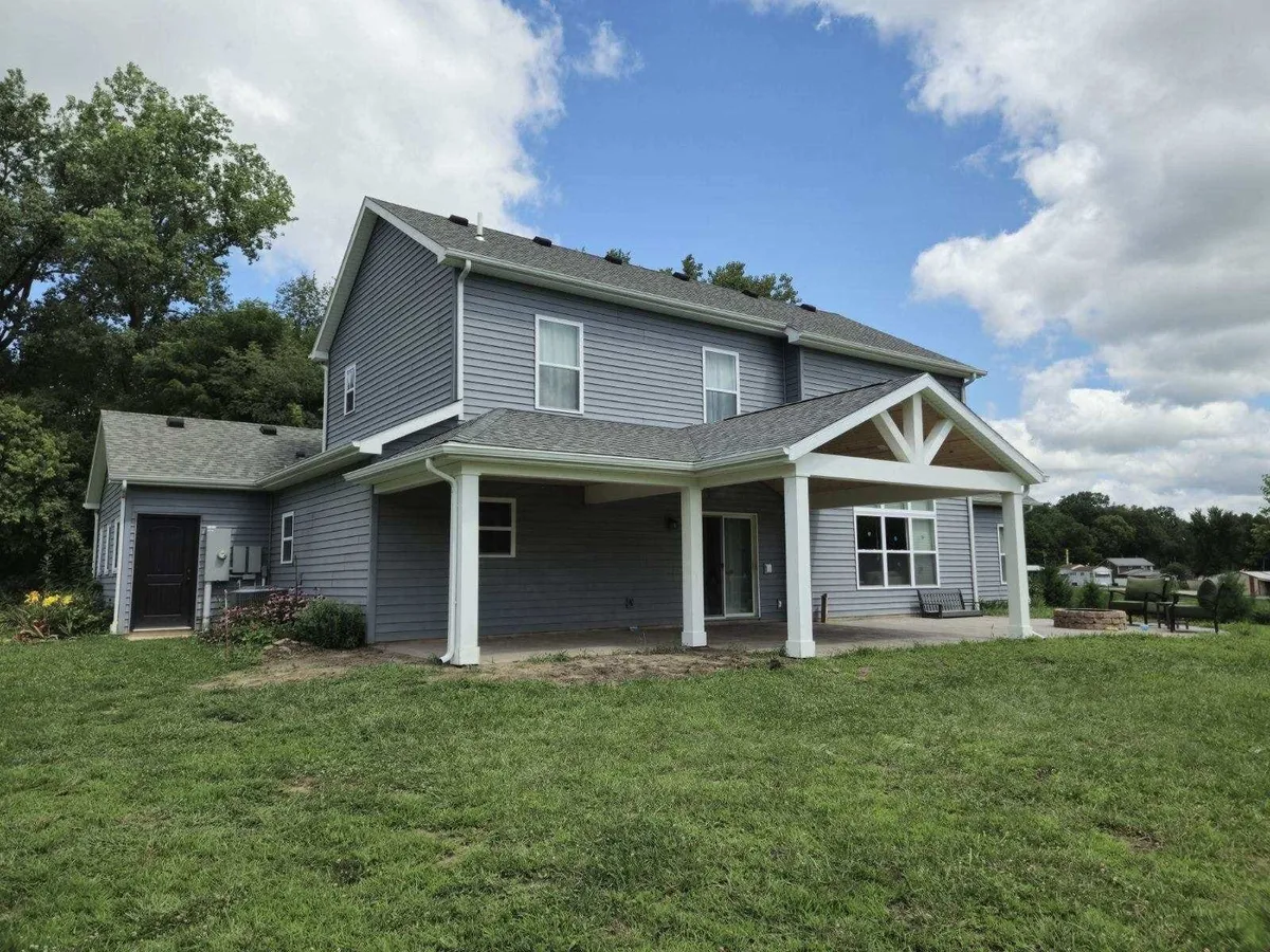 Completed gutter system on grey two-story home